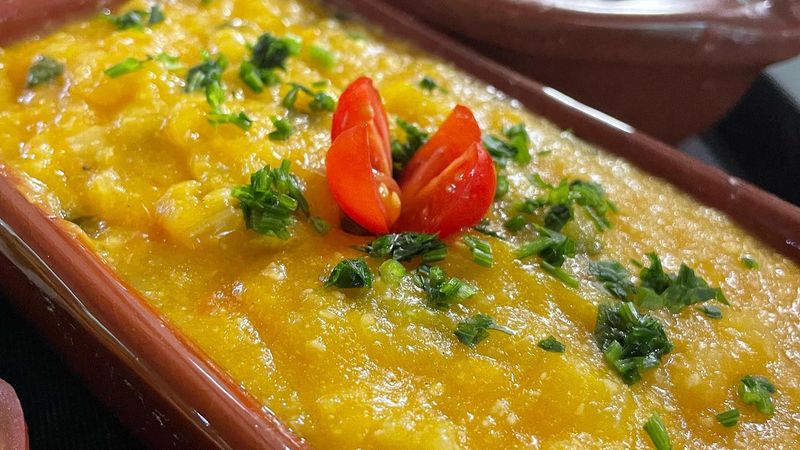 Travessa de virado de banana enfeitado com tomate e salsinha, no restaurante Sabores do Quilombo
